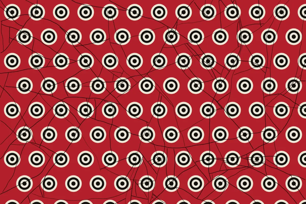 A wax print: cream and black targets over deep red, with the crackle
                  veins the dye leaves behind.
